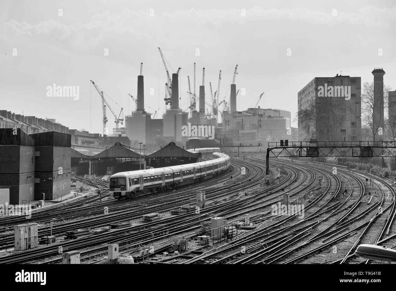 Passagier Zug nähert sich London Victoria mit Battersea Power Station im Hintergrund Stockfoto