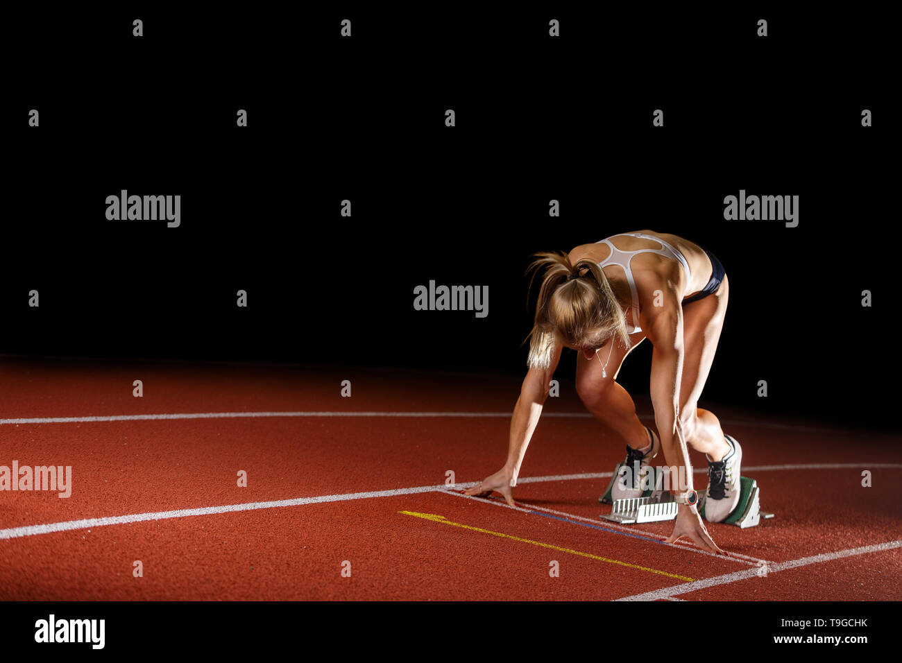 Läuferin Athlet starten laufen Sprint Rennen auf der Bahn. Leichtathletik sportliche Konzept Bild isoliert auf Schwarz mit Kopie Raum Stockfoto