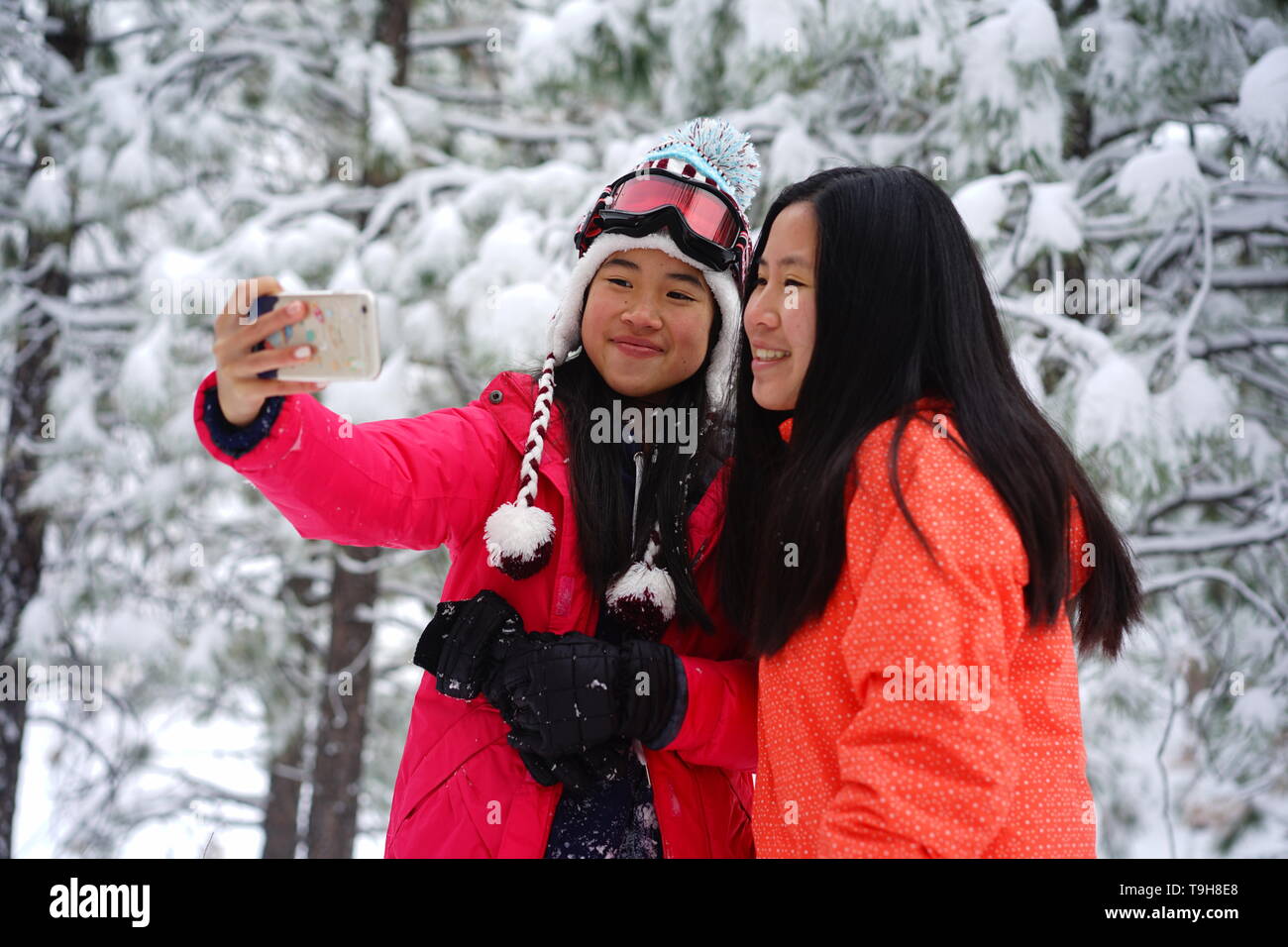 Zwei Mädchen im Teenageralter ein selfie beim Spielen im Schnee Stockfoto
