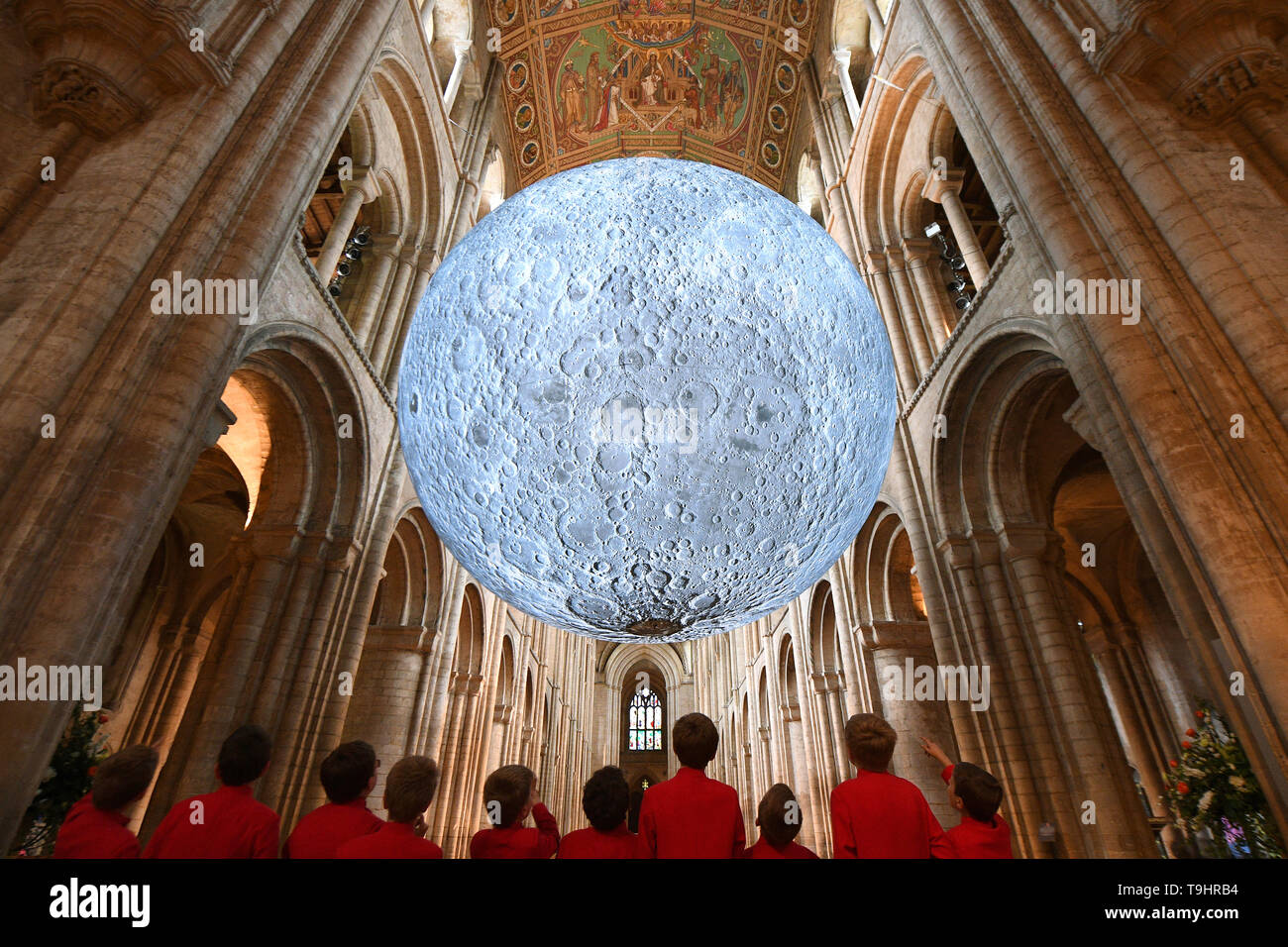 Chorknaben ansehen Luke Jerram's 'Museum der Installation der Mond' an die Kathedrale von Ely in Cambridgeshire. Die 7 Meter Durchmesser Replik der Mond ist die Hauptattraktion in der Kathedrale Science Festival", die Begrenzung des Himmels", die zum 50. Jahrestag der ersten Mondlandung feiert. Stockfoto