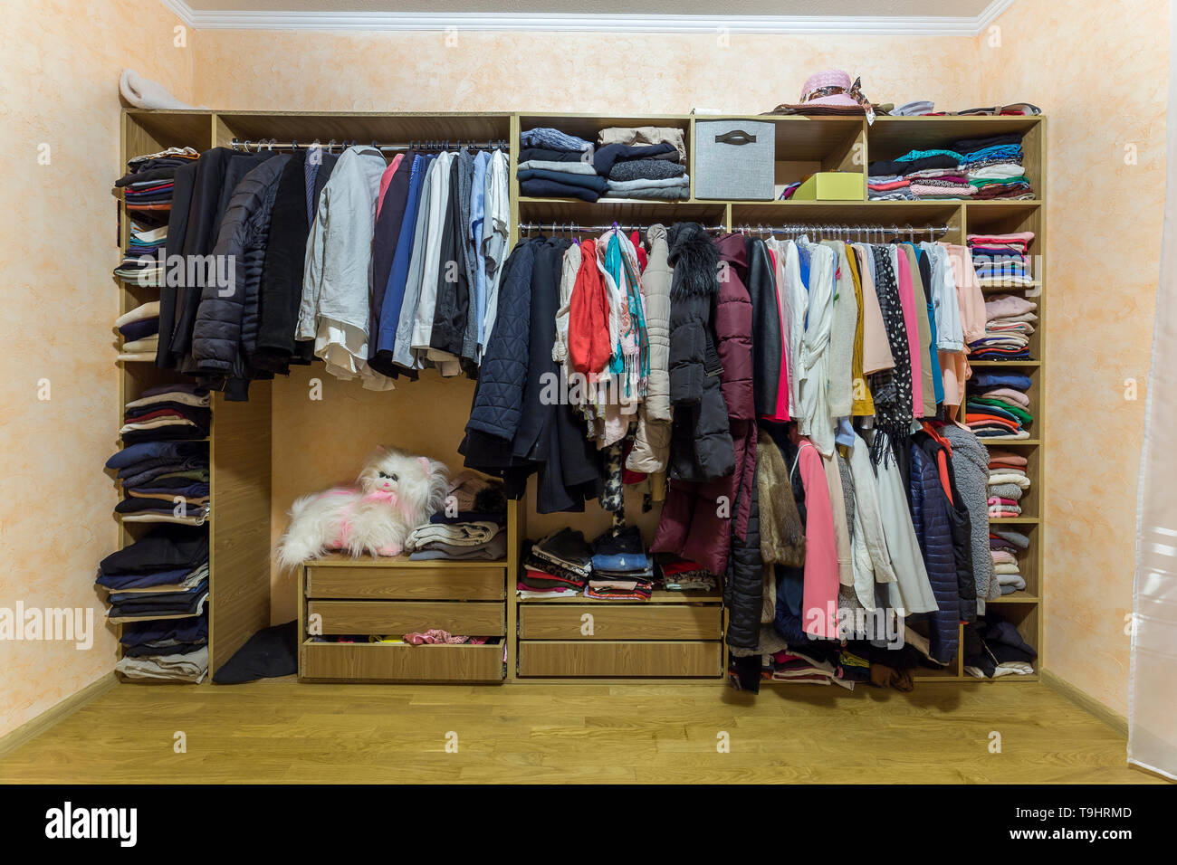 Öffnen dressing Schrank Kleiderschrank voll von verschiedenen männlichen und weiblichen bunte Kleidung und Zubehör auf Kleiderbügeln und Regal. Moderne Möbel, komfortable h Stockfotografie