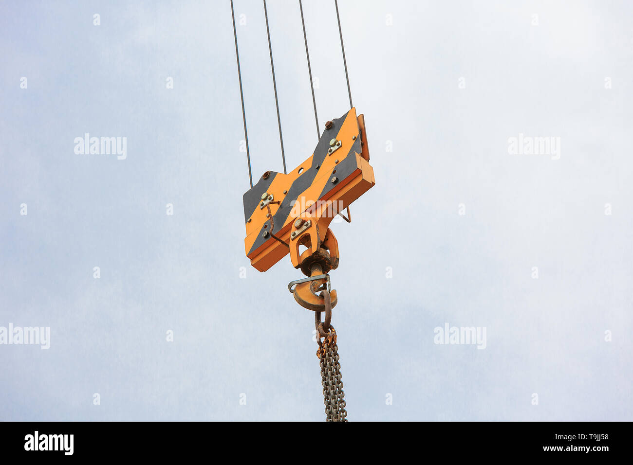 Kran Lasthaken gegen den Himmel mit Wanderwegen und Kette. Stockfoto