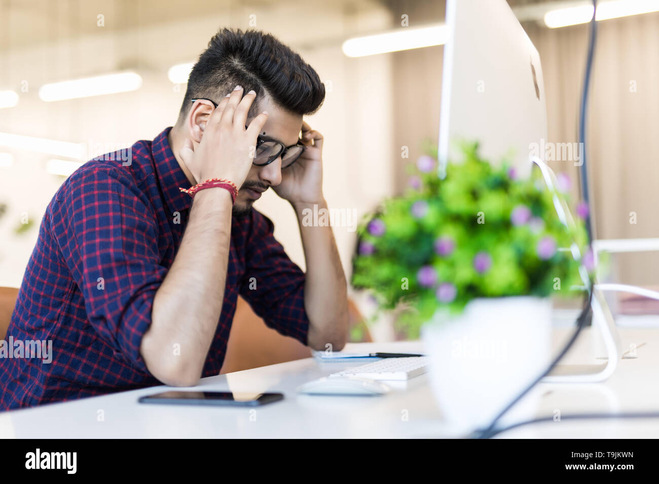 Müde und besorgt, Inder am Arbeitsplatz im Büro Stockfoto