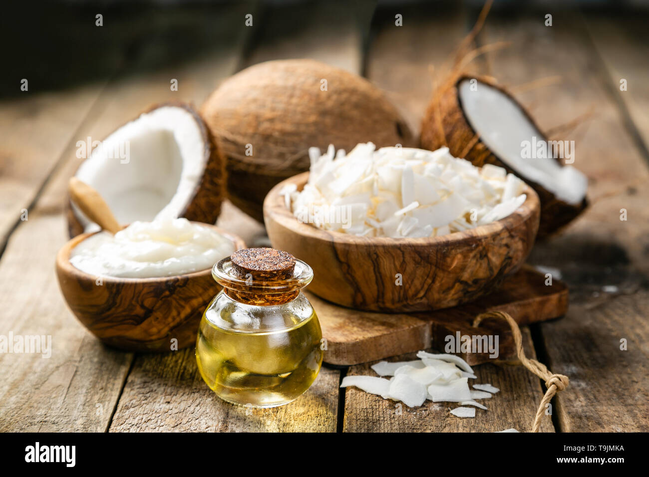 MCT Kokosöl Konzept - Kokosnüsse, Butter und Öl auf Holz Hintergrund Stockfoto