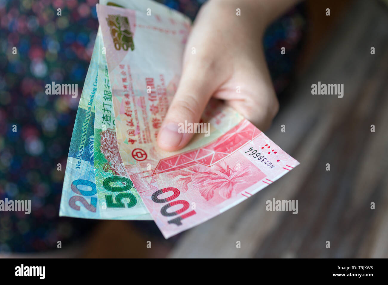 Eine Hand, die Hongkong Dollar (HKD) in bar Stockfoto