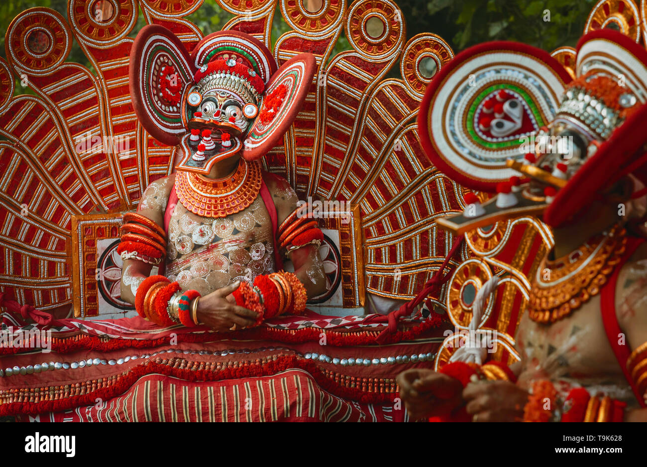Ein theyyam Performer in voller bunten Kostüm, Maske und Make-up während der späten Nacht Leistung des Theyyam in der Nähe von Srinagar, Kerala, Indien. Stockfoto