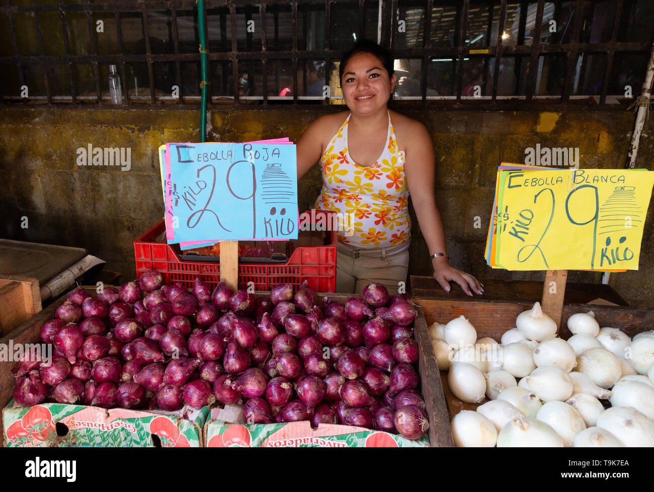 Mexikanischen Markt - eine junge Mexikanerin Verkauf Zwiebeln in ihrem Stall, Merida Food Market, Merida Yucatan Mexiko Lateinamerika Stockfoto