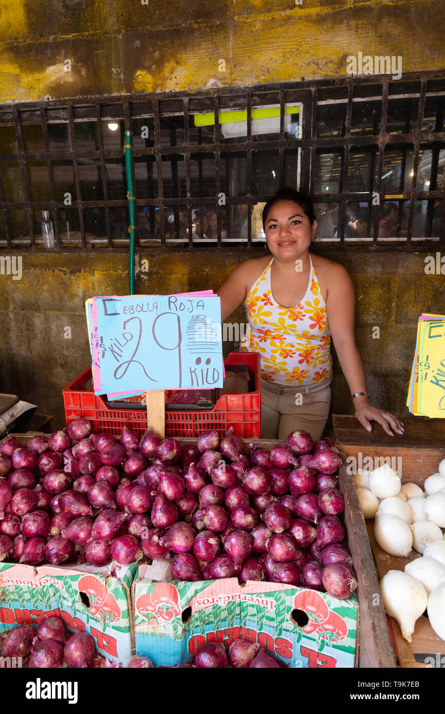 Mexikanischen Markt - eine junge Mexikanerin Verkauf Zwiebeln in ihrem Stall, Merida Food Market, Merida Yucatan Mexiko Lateinamerika Stockfoto