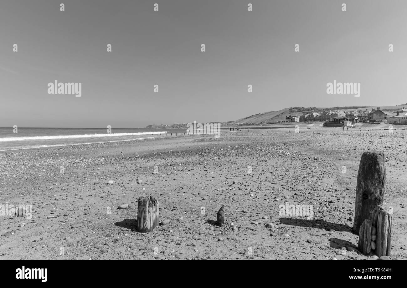 Sandsend Strand. Verrotten Wellenbrecher Beiträge sind die im Vordergrund und Gebäuden und einer Landspitze ist die Entfernung. Stockfoto