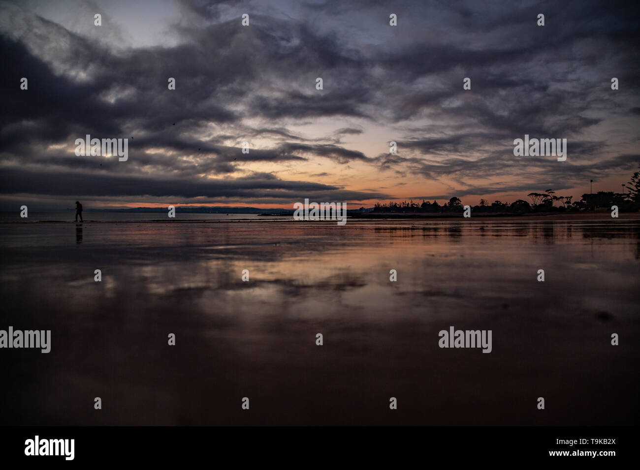 Strand Reflexion der Sonnenaufgang in Devonport Tasmanien, einsamer Wanderer Stockfoto