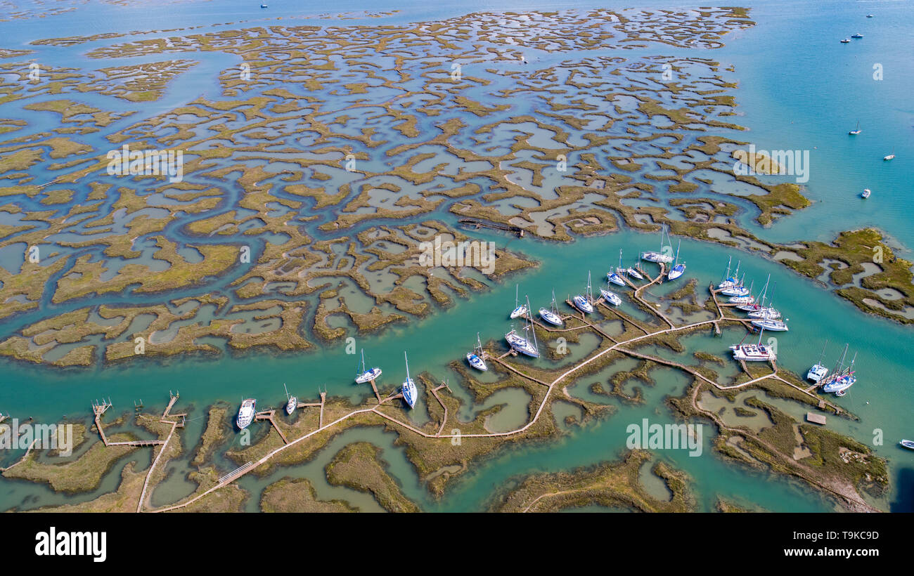 Bild vom Mai 15 zeigt Boote im Tollesbury Marina Saltings in Essex auf einem sonnigen Mittwoch Morgen gebunden, bevor sie sich in perfekten Bedingungen segeln auf einem anderen heißen Tag. Der natürliche Hafen an der Mündung des Flusses Blackwater in Essex gelegen ist. Yachten wurden gesehen, Hüpfenden auf dem Wasser im Tollesbury Marina in Essex heute (Mi), da das Vereinigte Königreich einen warmen und sonnigen Tag genießt. Die Sonne glitzerte auf dem Wasser von der Marina, die in der Eröffnungssequenz der populären ITV drama Lügner verwendet wurde. Stockfoto