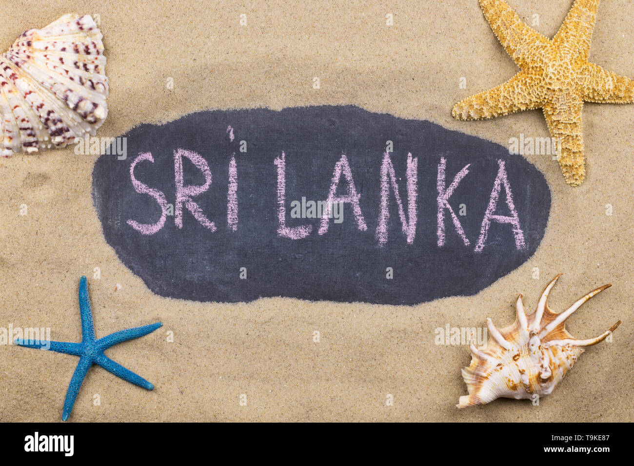 Handschriftliche Wort SRI LANKA mit Kreide geschrieben, unter Muscheln und Seesterne. Ansicht von oben Stockfoto