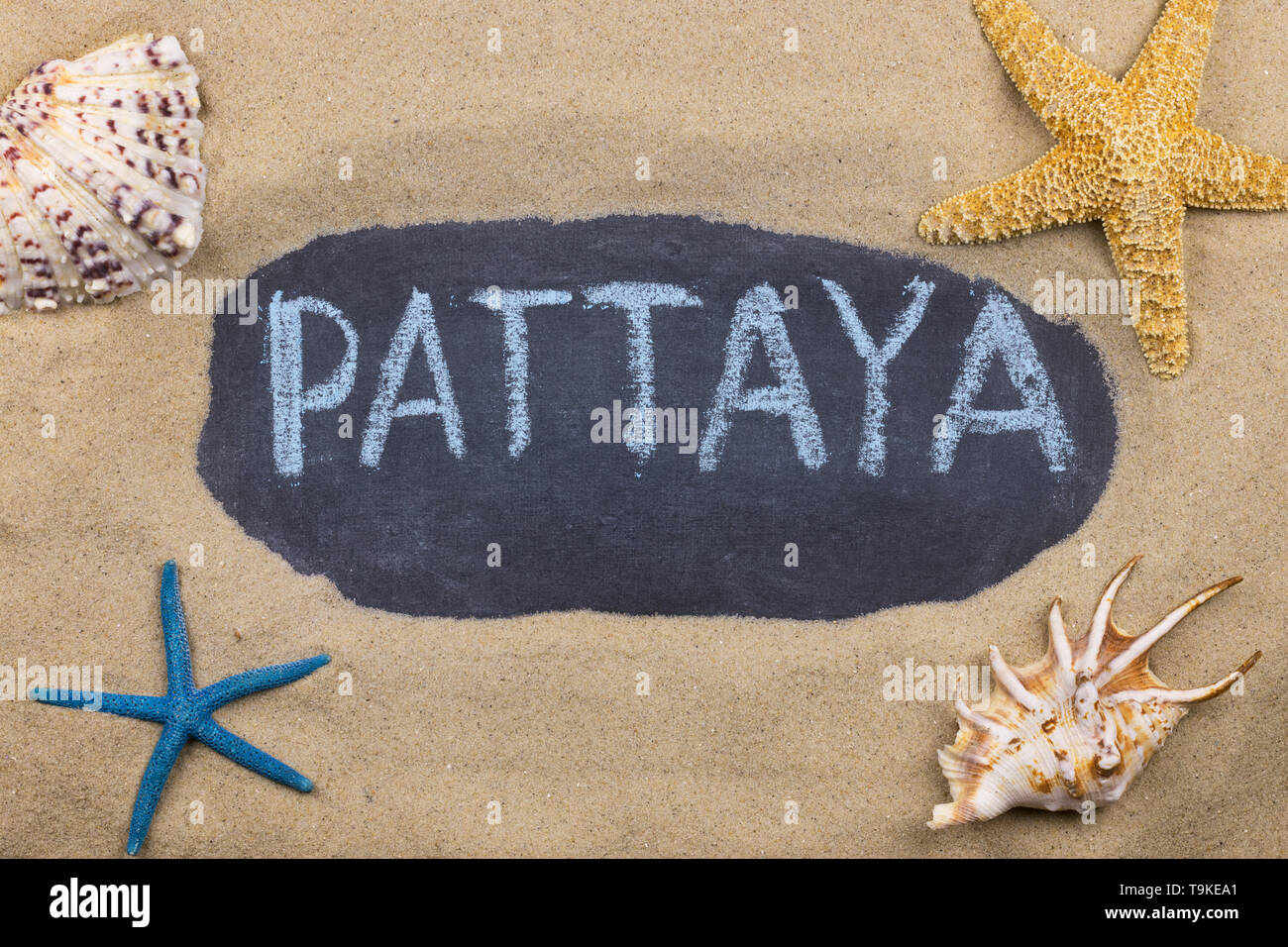 Handschriftliche Wort PATTAYA mit Kreide geschrieben, unter Muscheln und Seesterne. Ansicht von oben Stockfoto