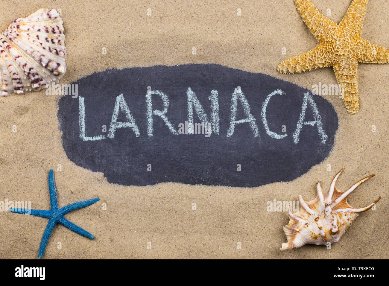 Handschriftliche Wort LARNACA mit Kreide geschrieben, unter Muscheln und Seesterne. Ansicht von oben Stockfoto