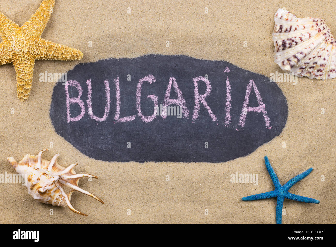 Handschriftliche Wort Bulgarien mit Kreide geschrieben, unter Muscheln und Seesterne. Ansicht von oben Stockfoto