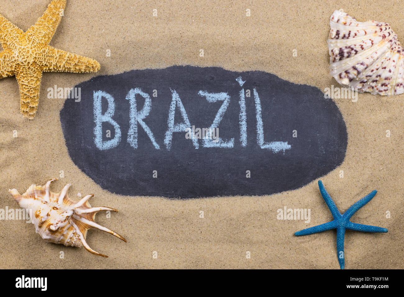 Handschriftliche Wort Brasilien mit Kreide geschrieben, unter Muscheln und Seesterne. Ansicht von oben Stockfoto