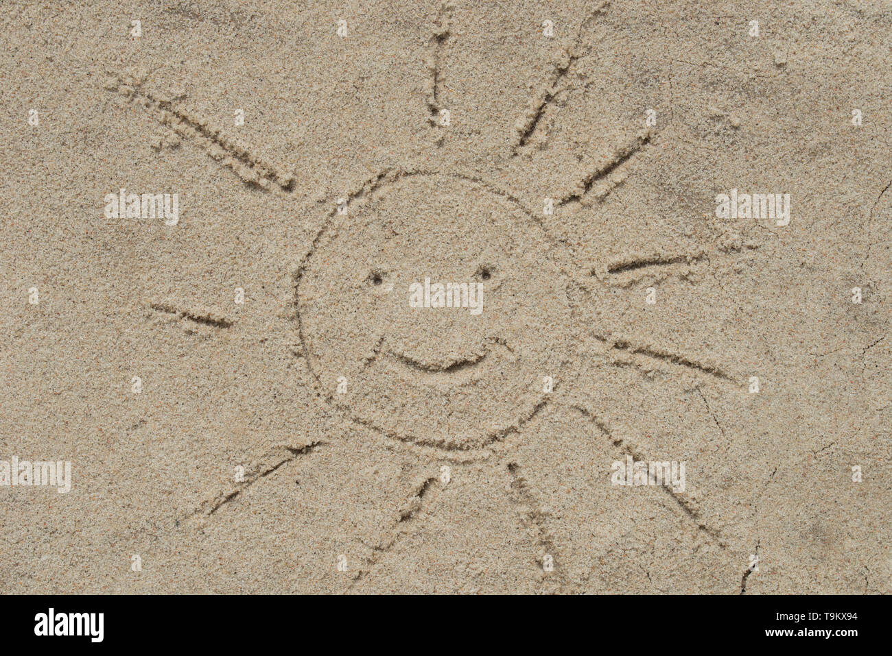 Lächelnde Sonne auf Sand Zeichnung closeup Stockfoto