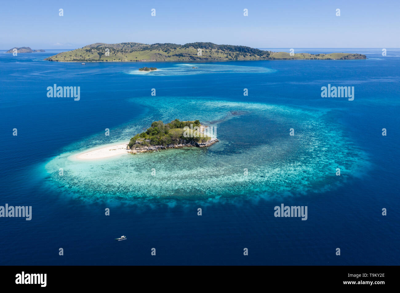 Aus der Vogelperspektive, einem idyllischen tropischen Insel ist durch ein gesundes Korallenriff im Komodo National Park, Indonesia umgeben. Stockfoto