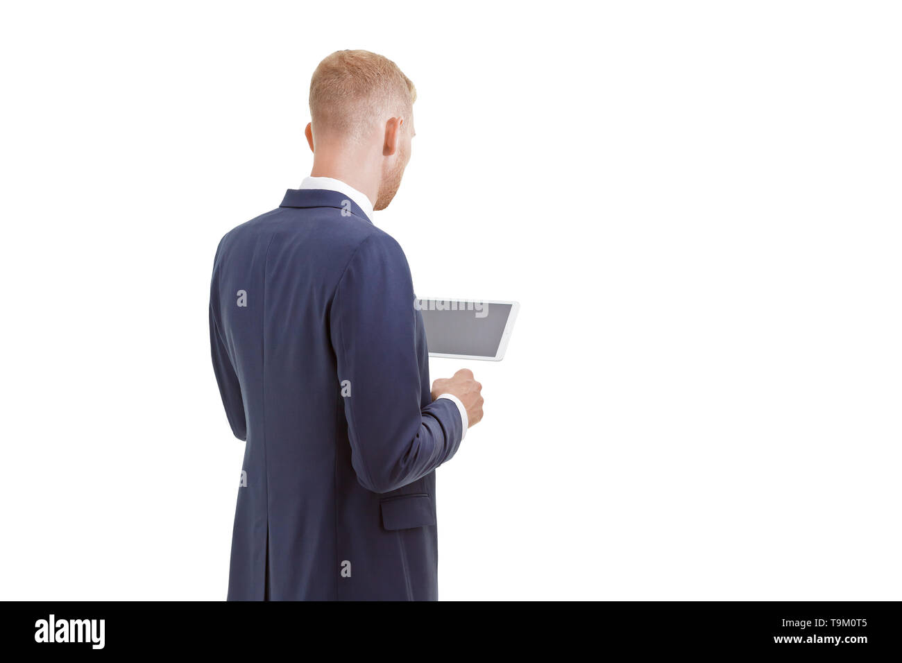 Blonder Mann mit Bart in einer blauen Jacke Holding einen Tablet-PC, Rückansicht, isoliert, kopieren. Stockfoto