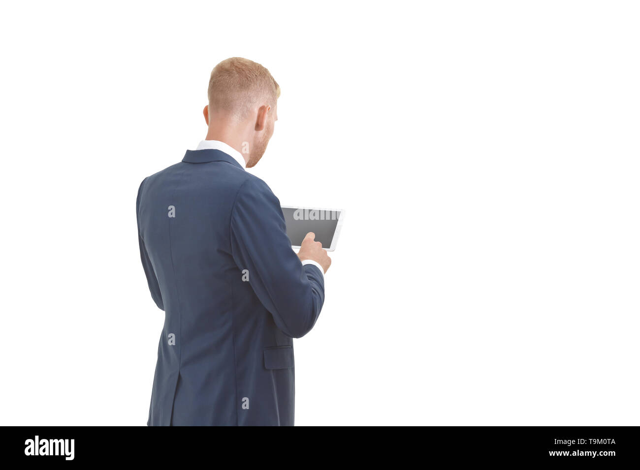 Blonder Mann mit Bart in einer blauen Jacke Holding einen Tablet-PC, Rückansicht, isoliert, kopieren. Stockfoto