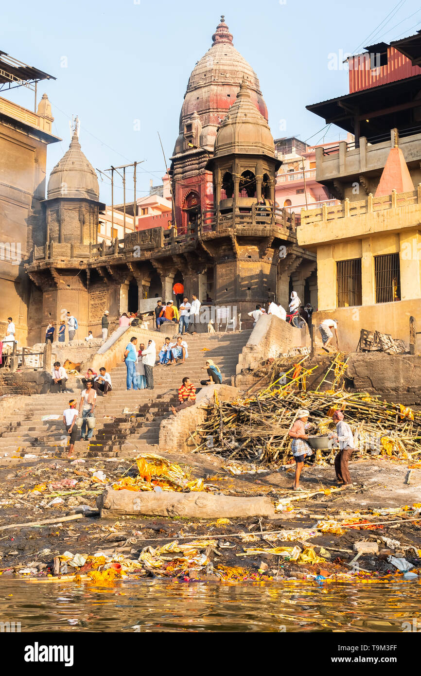 Varanasi, Indien, 27. März 2019 - Ganges mit Manikarnika Ghat, einem der bekanntesten hinduistischen Krematorium - eine Leiche wird durch das heilige Feuer verbrannt Stockfoto
