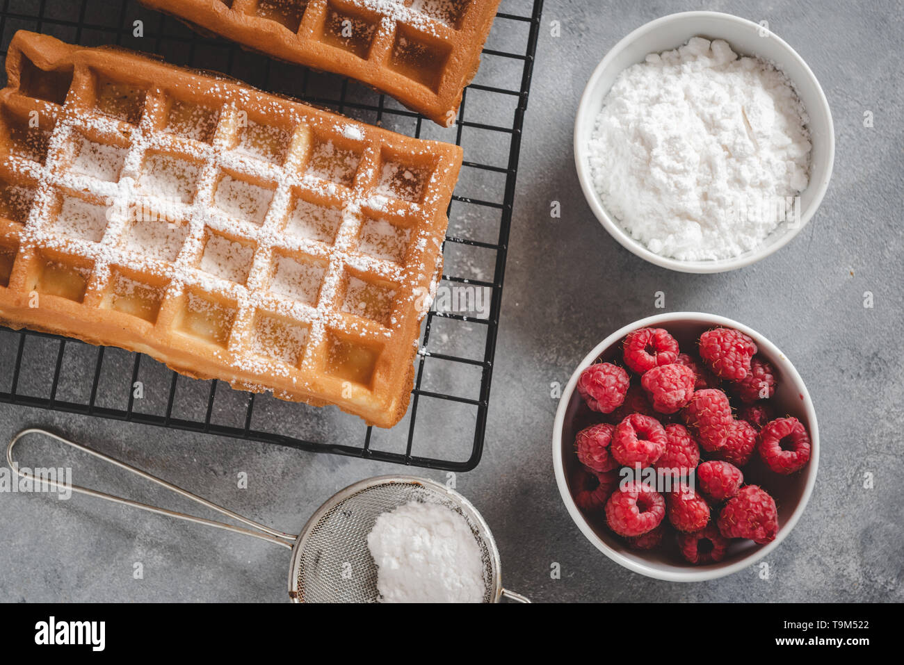 Selbstgemachte Waffeln mit Himbeeren auf grau Tabelle Stockfoto