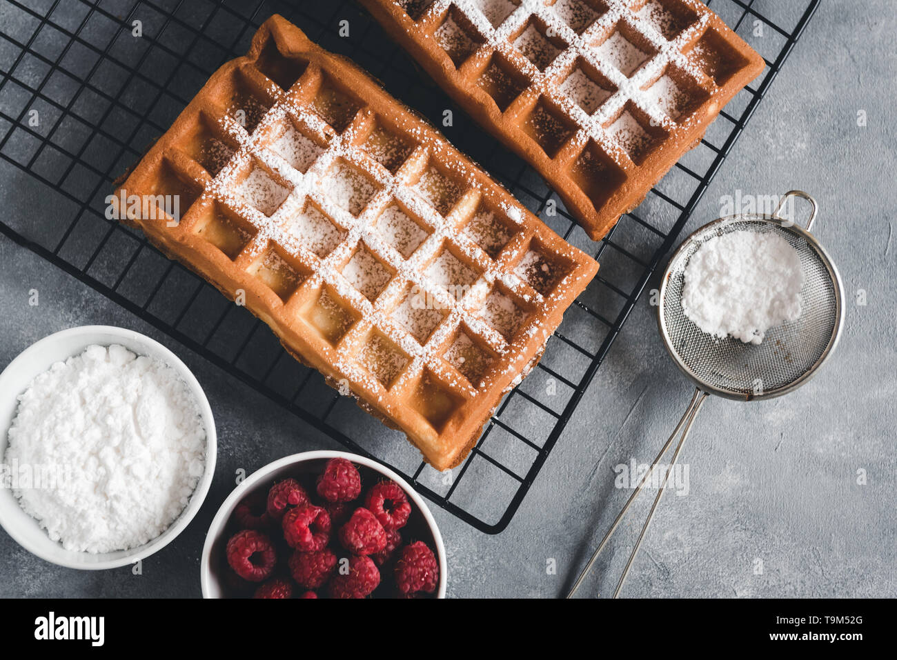 Selbstgemachte Waffeln mit Himbeeren auf grau Tabelle Stockfoto