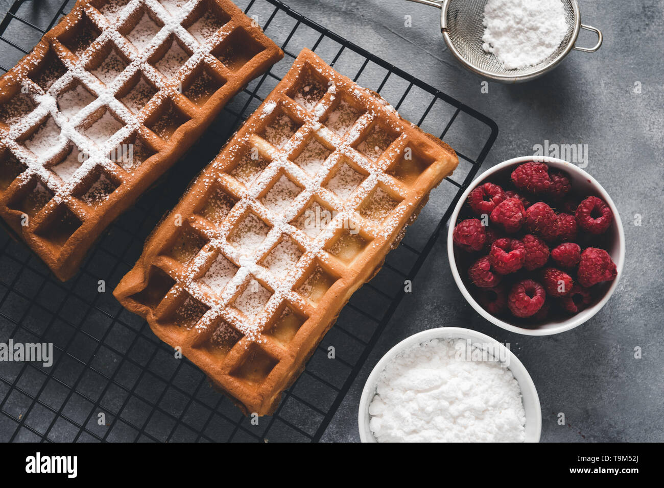 Selbstgemachte Waffeln mit Himbeeren auf grau Tabelle Stockfoto