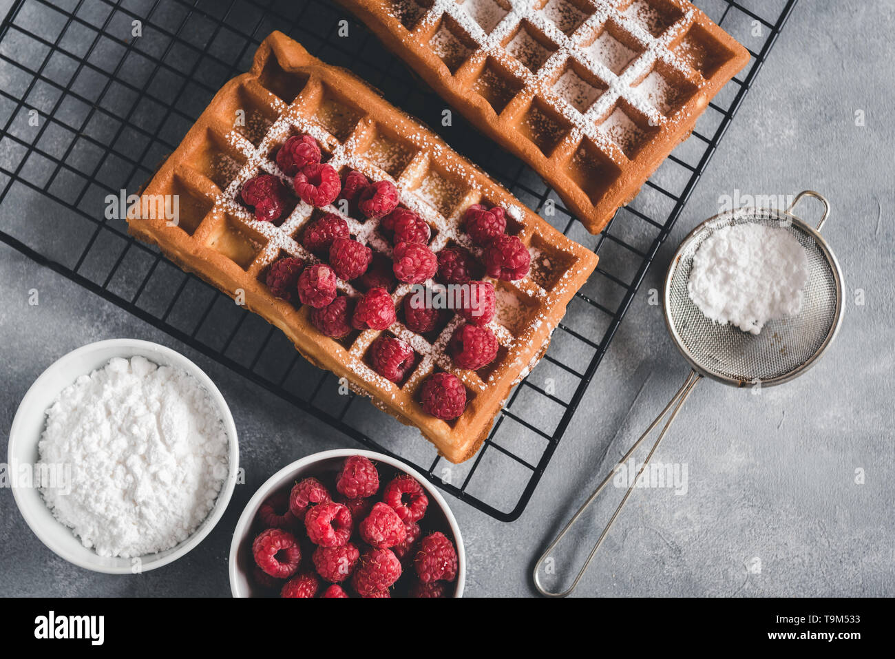 Selbstgemachte Waffeln mit Himbeeren auf grau Tabelle Stockfoto