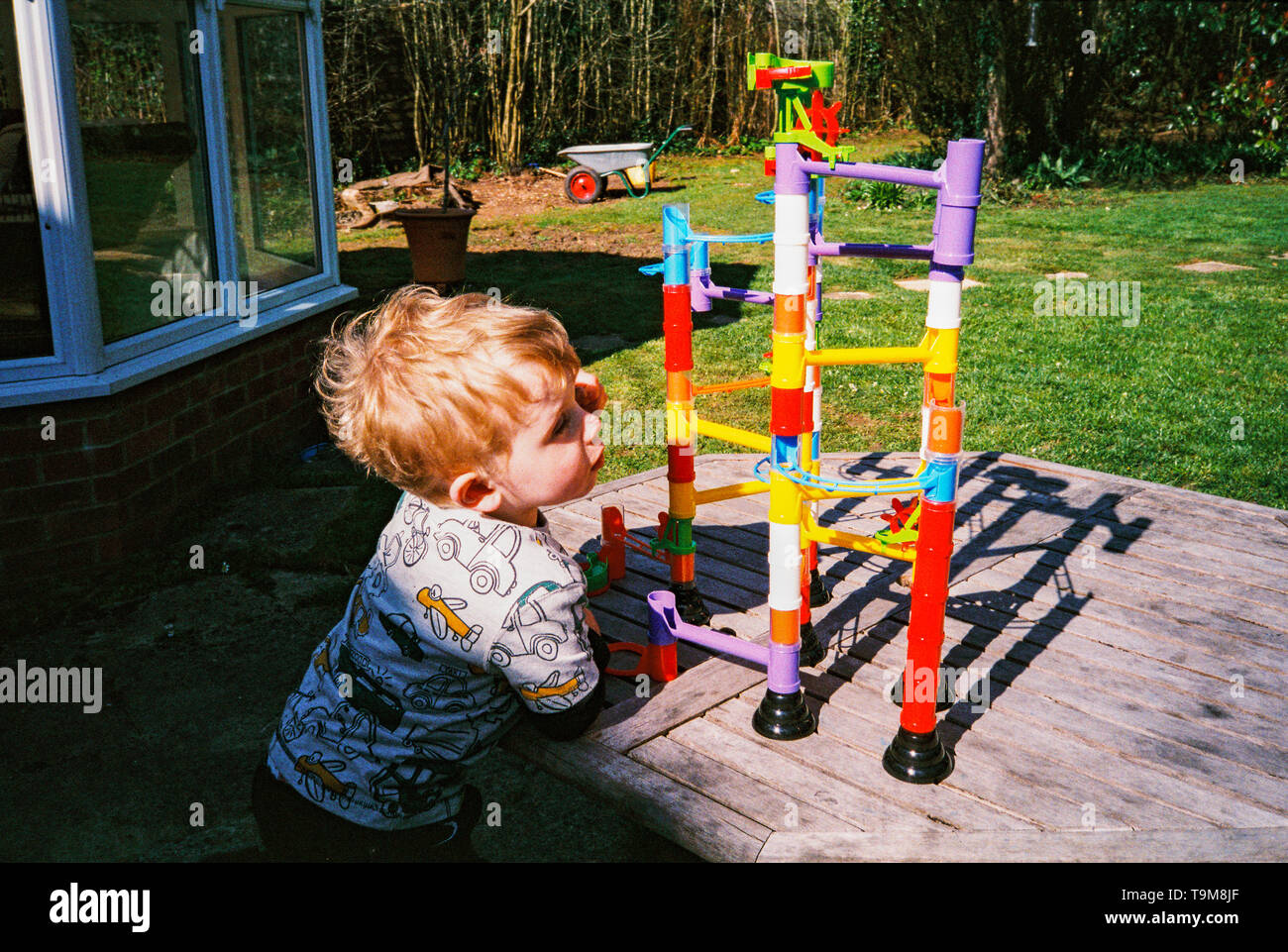 Zwei Jahre alte Junge spielt mit einem Spielzeug Kugelbahn. Medstead, Hampshire, England, Vereinigen Königreich. Stockfoto