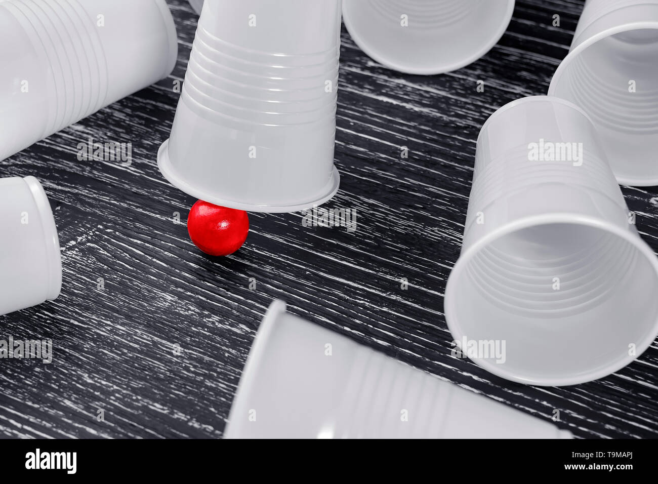 Die Schale in der Schale Spiel mit einem roten Ball. Um Lüge leere verlieren Cups. Das Konzept der Bargeld Gewinne im Glücksspiel Stockfoto