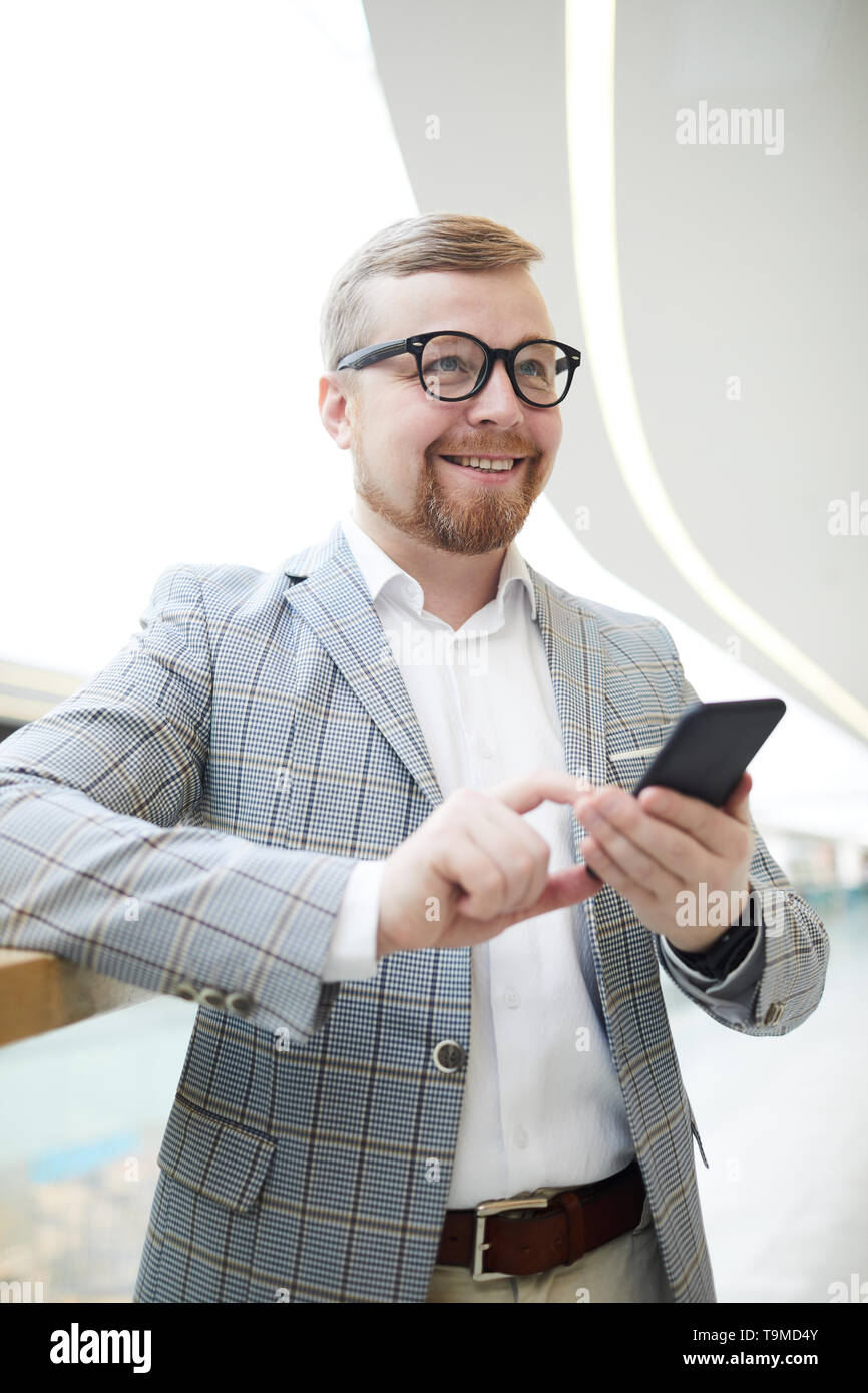 Positive mollig Mann über sms Denken Stockfoto