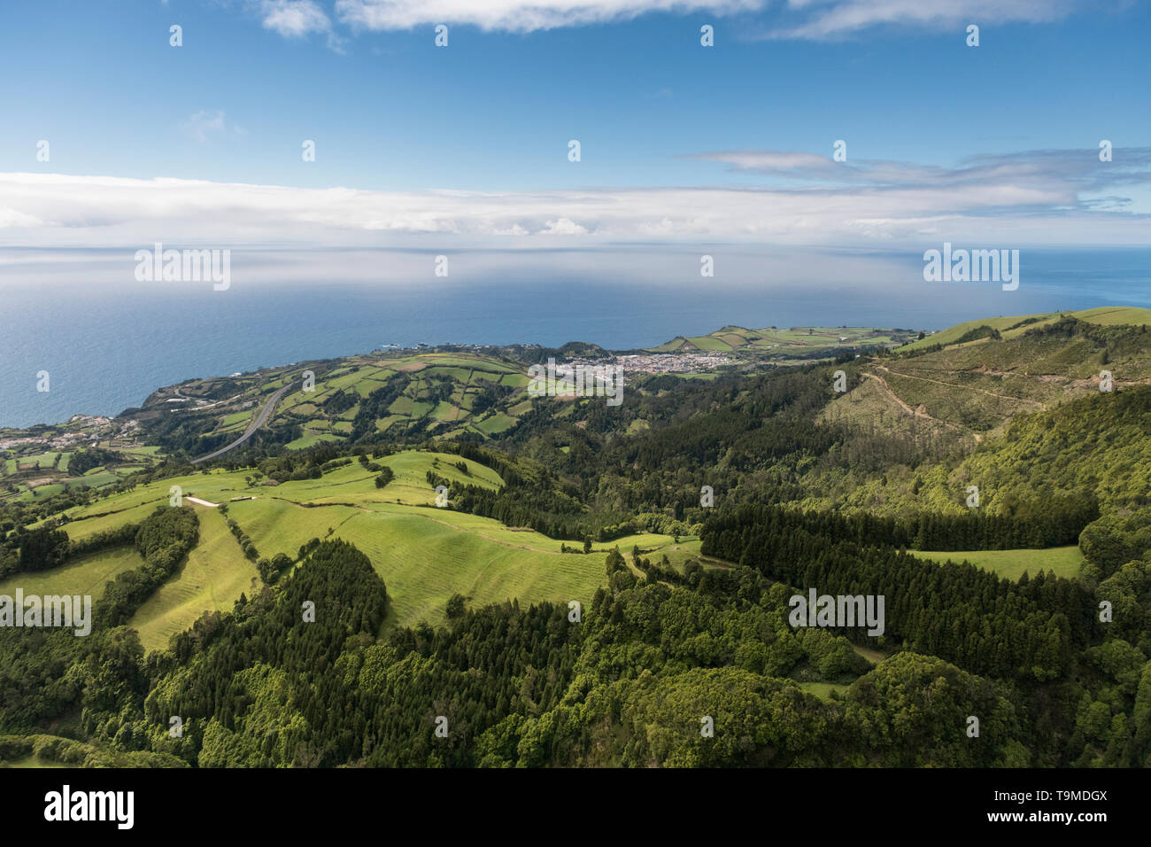 Antenne Landschaft Blick auf grüne Hügel, Wiesen und das Meer gesehen, wie von Lagoa do Fogo (See/Lagune von Feuer) in Richtung der Südküste von Sao Stockfoto