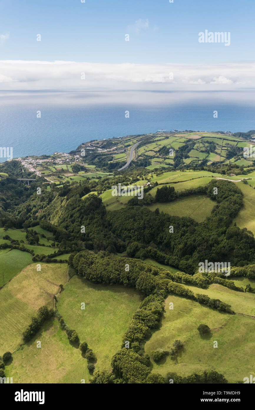 Antenne Landschaft Blick auf grüne Hügel, Wiesen und das Meer gesehen, wie von Lagoa do Fogo (See/Lagune von Feuer) in Richtung der Südküste von Sao Stockfoto