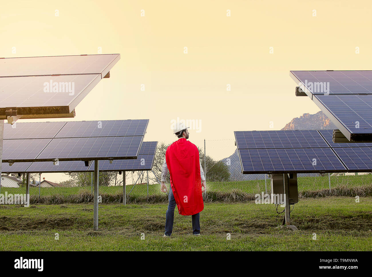 Erfolgreicher Geschäftsmann in der Nähe an der Photovoltaikanlage, wie Superman Stockfoto