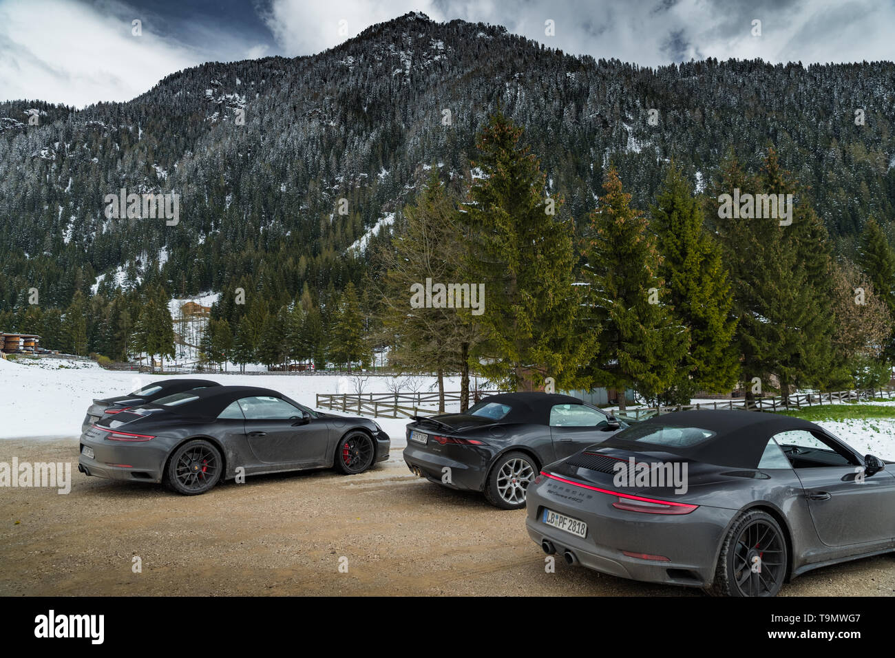 Italien, Trentino, die Gruppe der Luxus-Sportwagen macht einen Halt auf dem einige Dorf, schneebedeckte Feld auf dem Hintergrund, Porsche Stockfoto