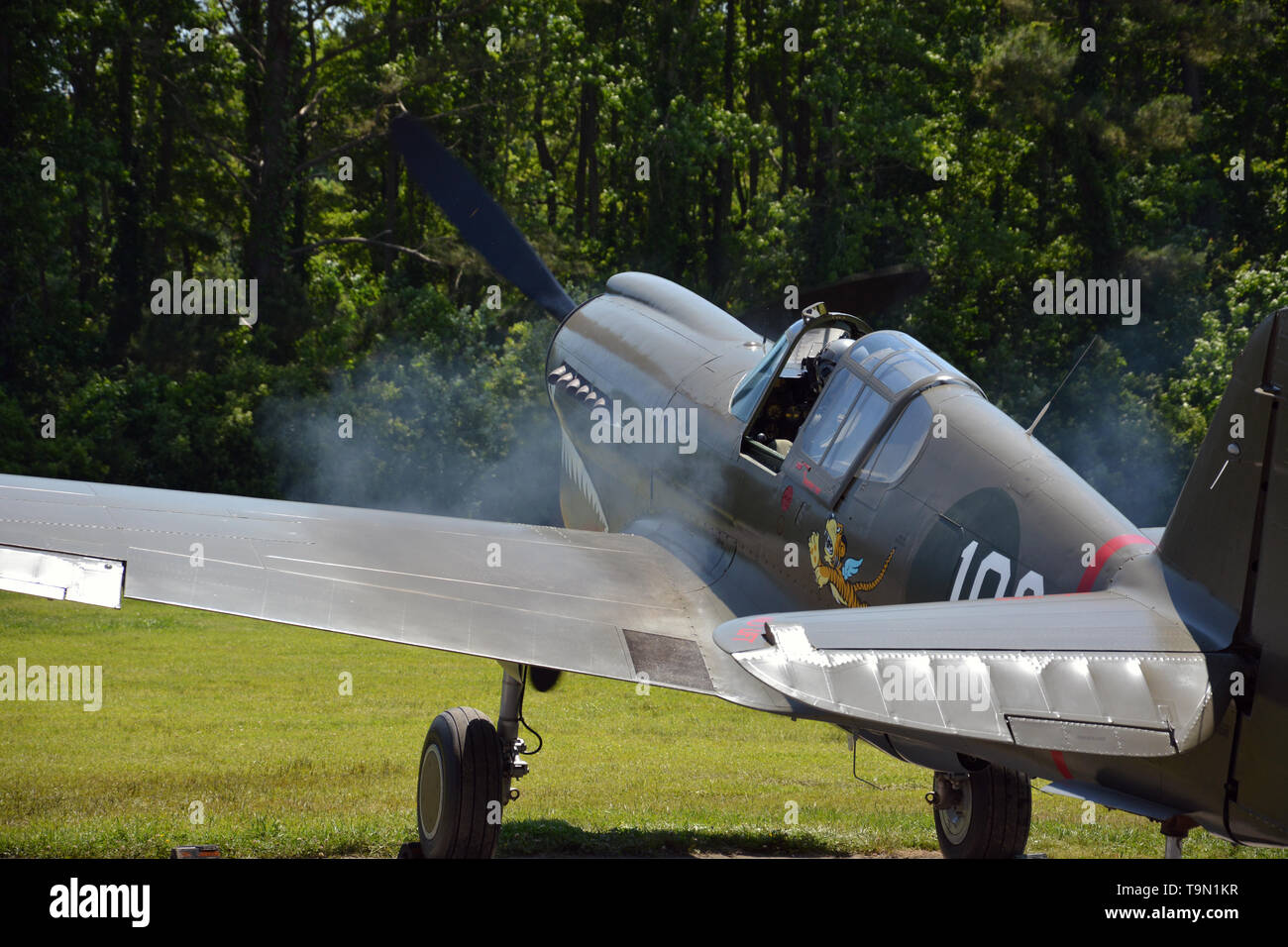 Rauch, die Schläge der Motor einer Curtiss P-40 Warhawk mit Flying Tiger insignia wie es bereitet für den Start in ein WWII air show in Virginia Beach VA Stockfoto