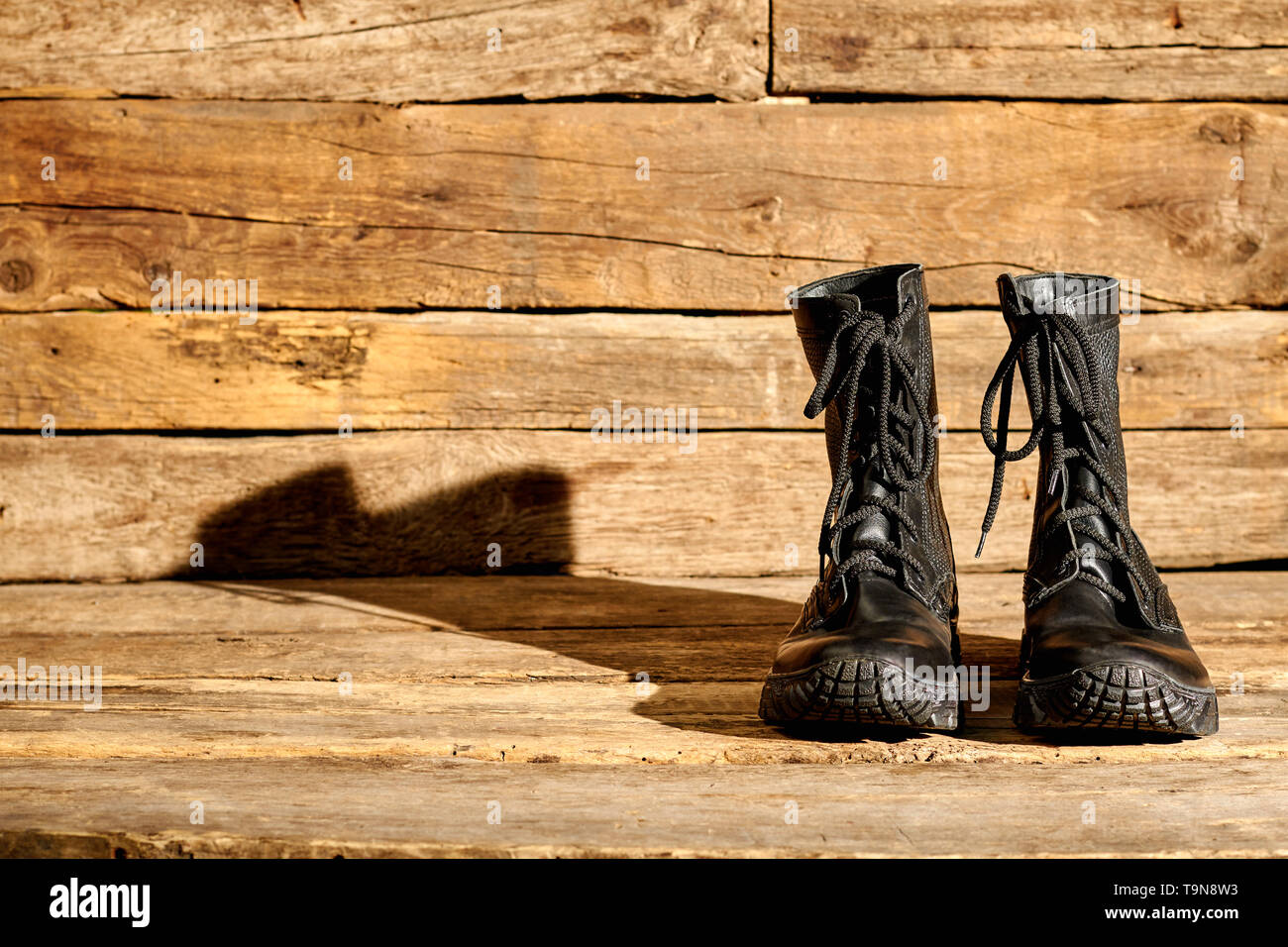 Bekämpfung der schwarzen Armee Stiefel auf Holz. Stockfoto