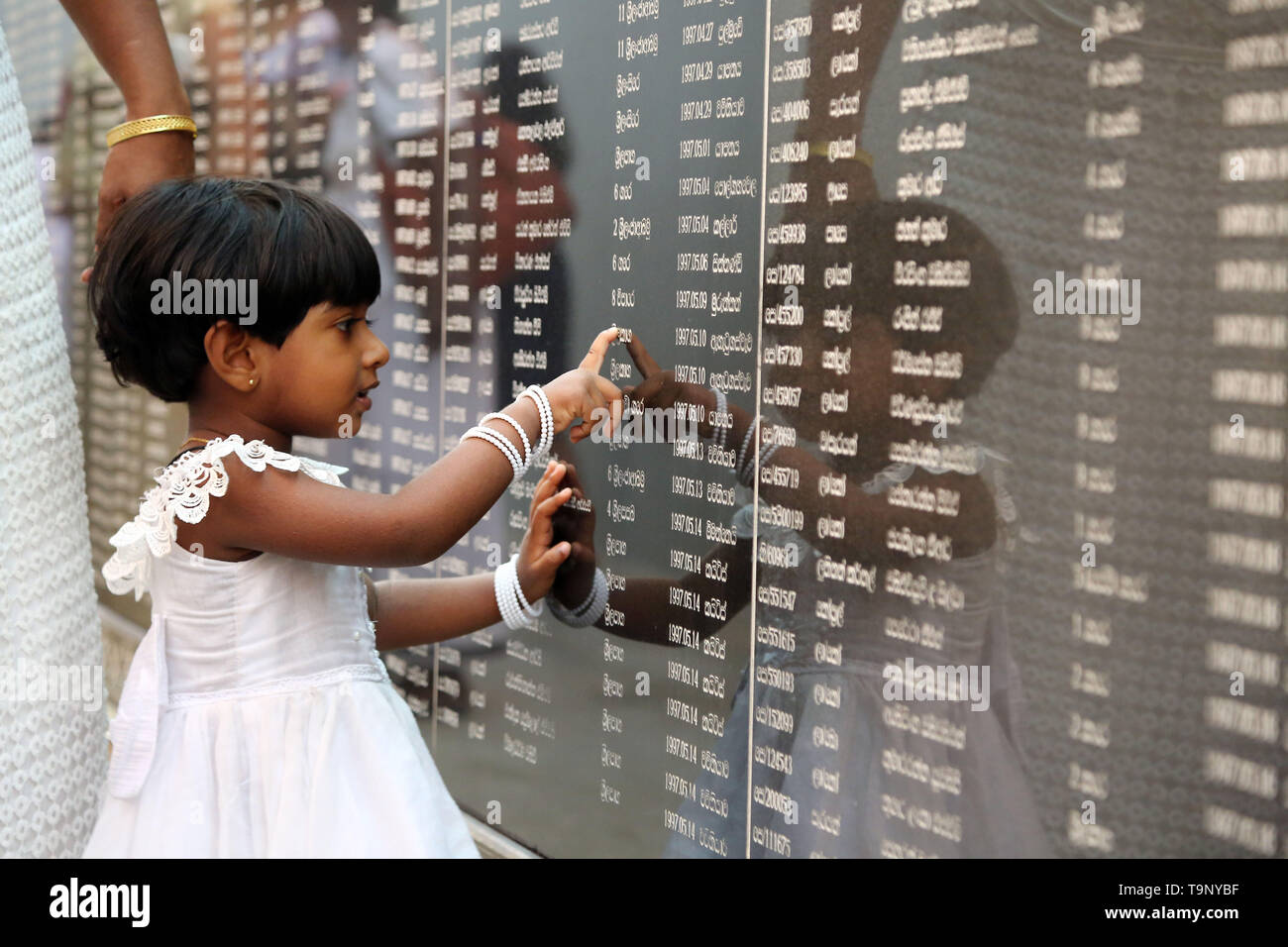 Colombo. 19 Mai, 2019. Eine Sri Lankan Mädchen liest die Namen der gefallenen Soldaten während einer Gedenkfeier in Colombo am 19. Mai 2019. Sri Lanka hielt einen Krieg Gedenkgottesdienst am Sonntag Abend Tribut an die Tausende von Soldaten und Menschen des Landes 30 getötet zu Pay-Jahr Bürgerkrieg gegen die Rebellen, die Tamil Tigers im Mai 2009 endete. Credit: ajith Perera/Xinhua/Alamy leben Nachrichten Stockfoto