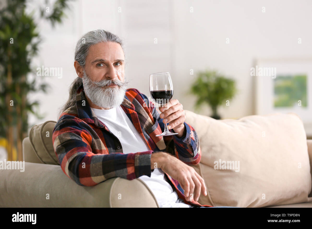 Älterer mann Wein trinken zu Hause Stockfoto