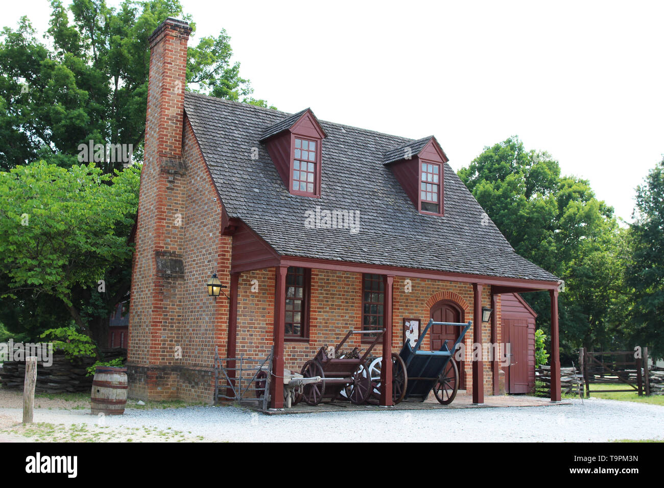 Im amerikanischen Kolonialstil Architektur: ein Backstein Bauernhaus mit einem offenen Lagerschuppen Stockfoto