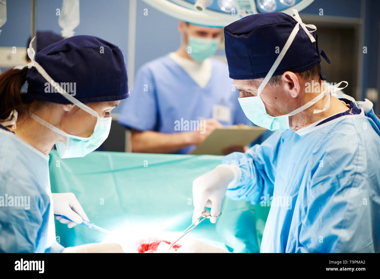 Beschäftigt Chirurgen über die OP-Tisch Stockfoto