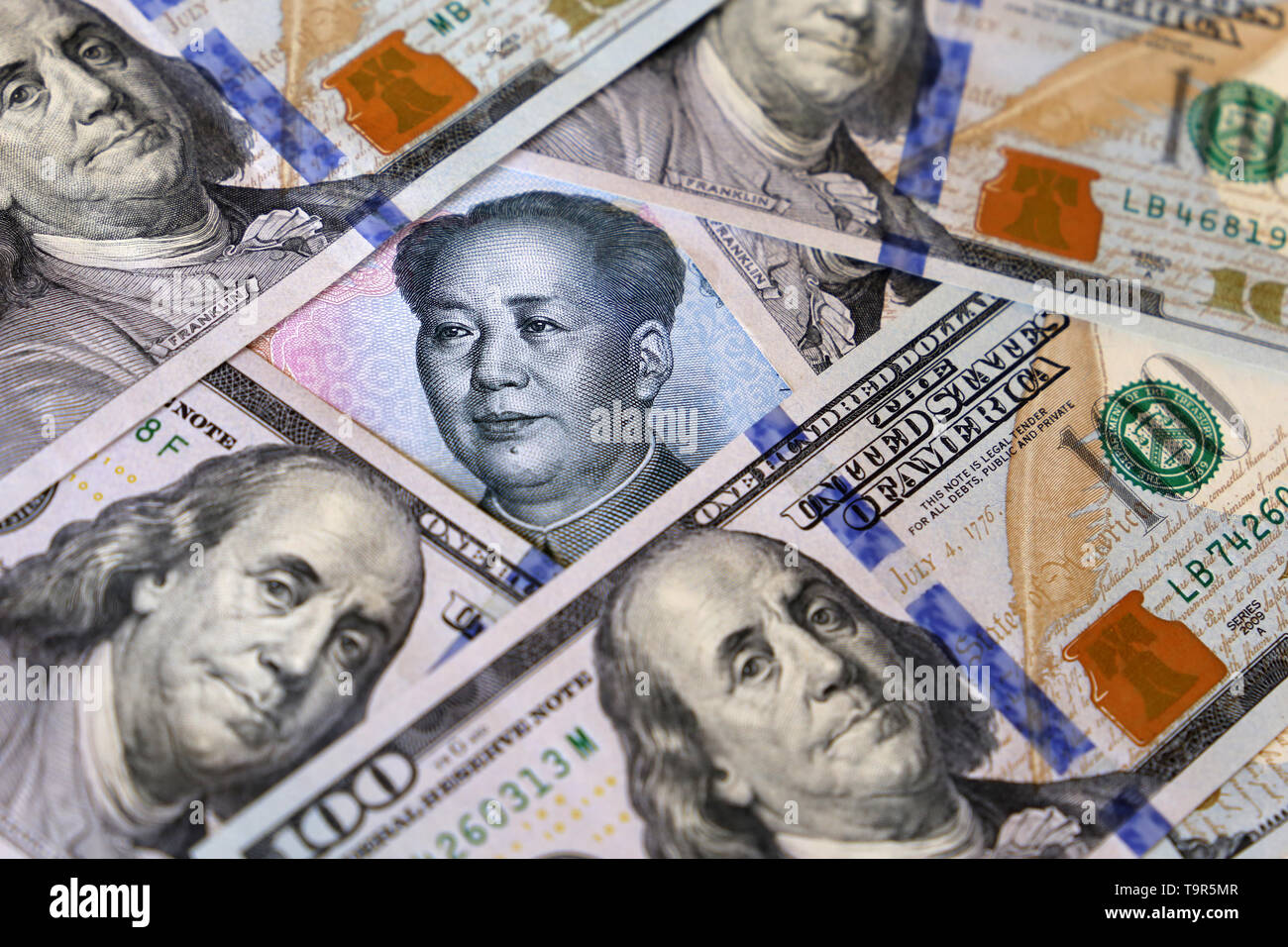 Chinese Yuan von US-Dollarnoten umgeben. Konzept der Handelskrieg zwischen China und den USA, wirtschaftliche Sanktionen, Handel und Investitionen Stockfoto