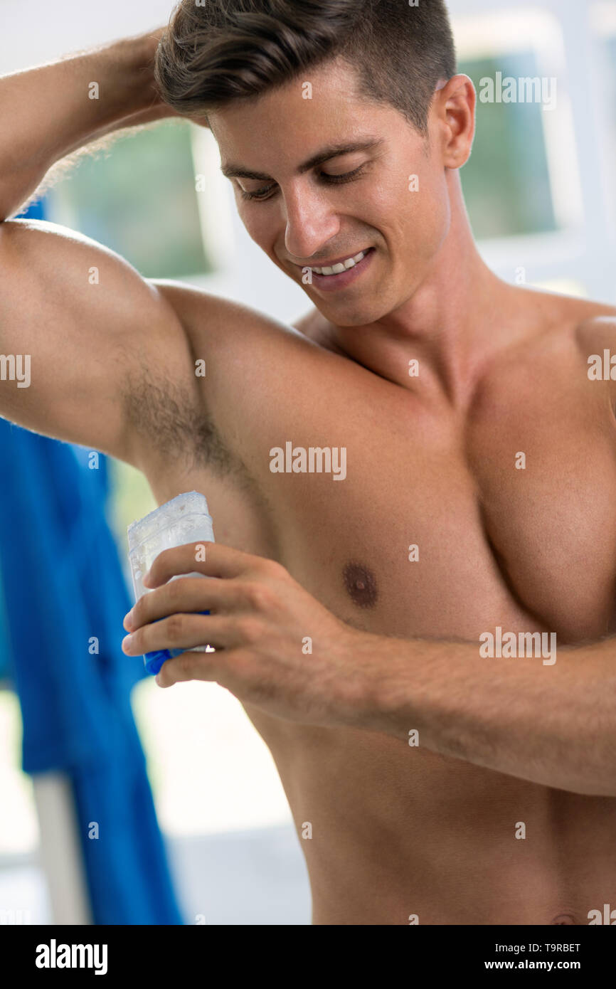 Junge schöne Männer deodorant Anwendung unter den Achseln Stockfoto
