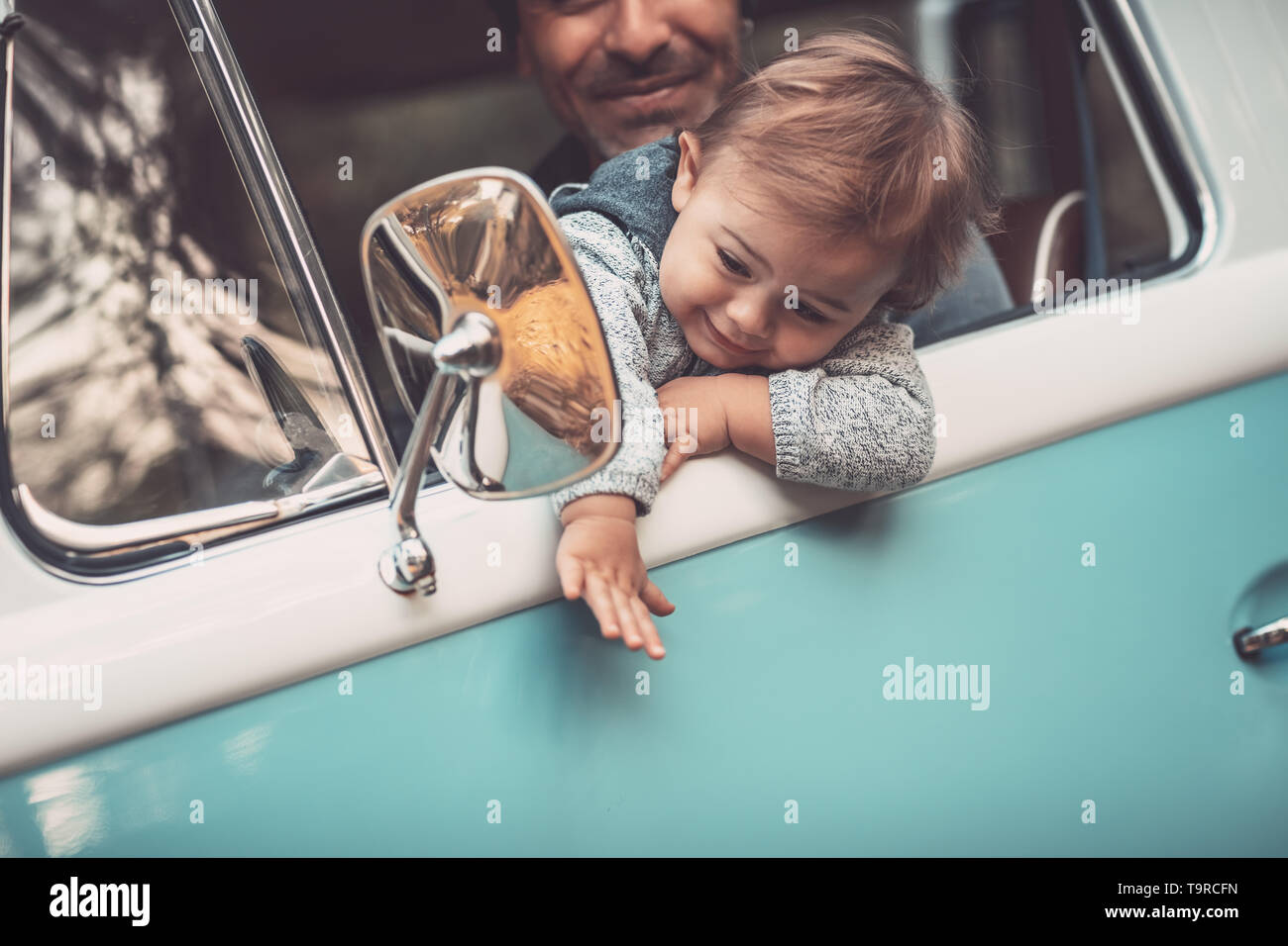 Porträt einer fröhlichen Vater mit niedlichen kleinen Sohn, der ein Auto fährt, Papa Lehre sein kostbares Baby einen Van zu fahren, mit Freude die Zeit togethe Stockfoto