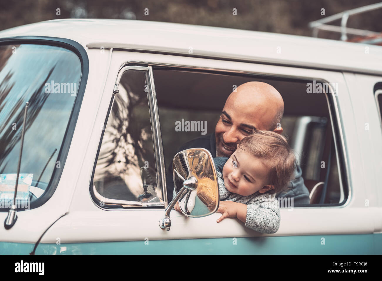 Kleiner Junge mit Vater Spaß im Auto, Papa und Sohn auf dem Fahrersitz sitzen im Van, Spielen und Blick in den Rückspiegel, glückliche fam Stockfoto