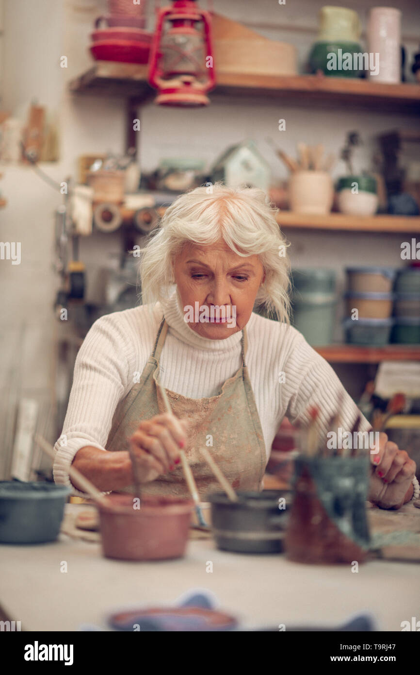 Ernsthafte hart arbeitende Frau mit einem kreativen Job Stockfoto