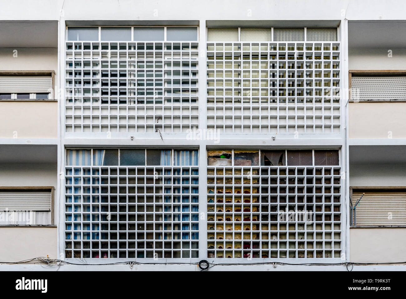 Detail Nahaufnahme der fünfziger Jahre Apartment Gebäude Fassade mit Fenster Rollläden und Beton Fenster Gitter im symmetrischen Muster und Reihen in Cascais Por Stockfoto