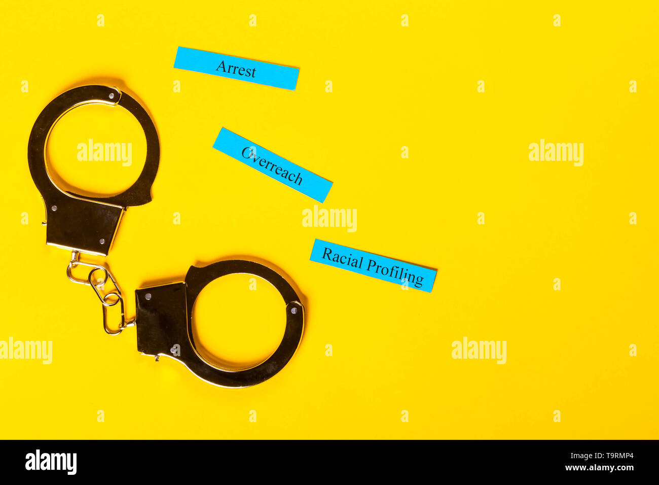 Kriminalität Konzept Handschellen zeigt auf einem gelben Hintergrund mit Rasse Profiling Stockfoto