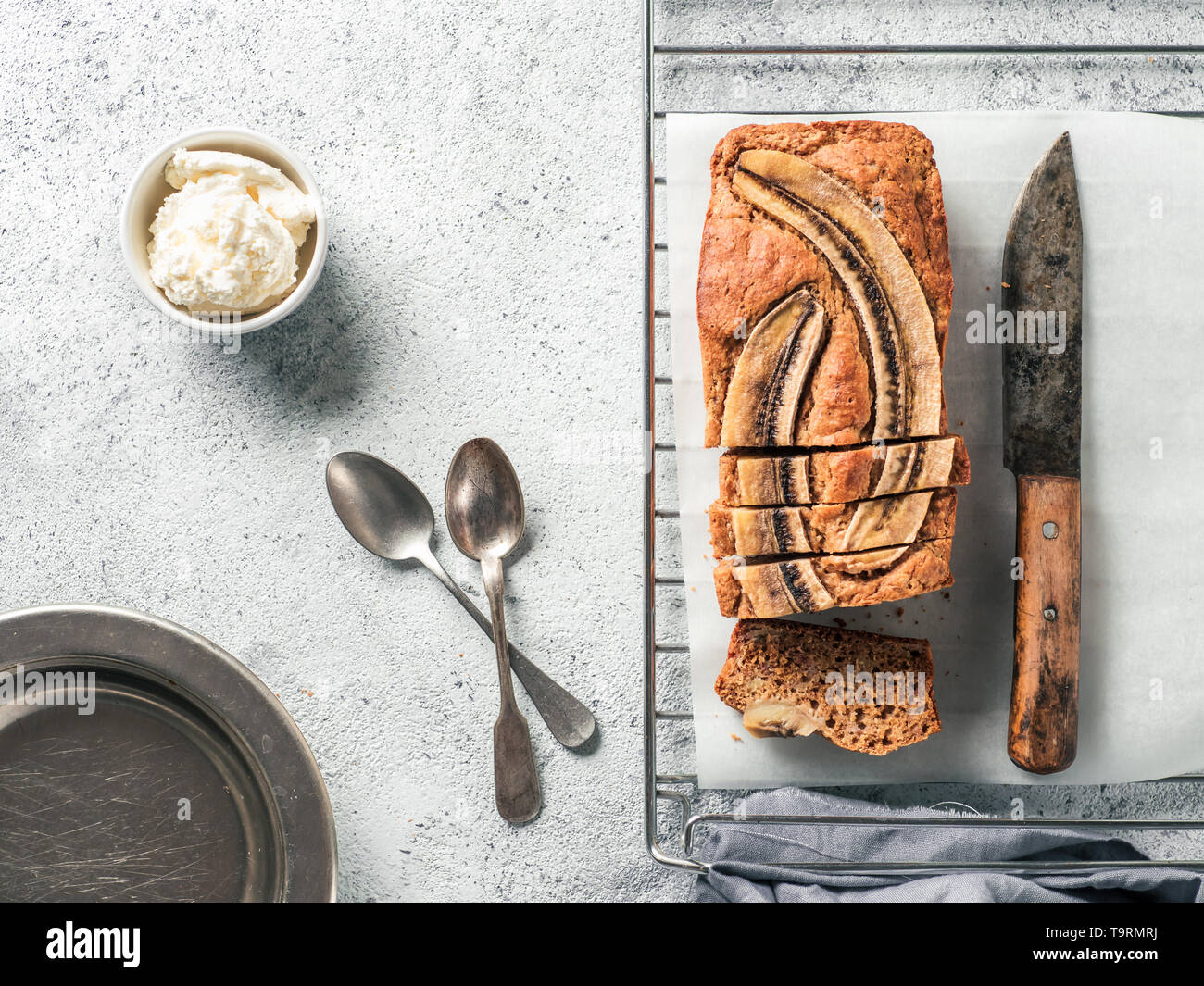 Butter, Zucker-freien Bananenbrot mit Hafermehl, weiche Quark und Honig. Blick von oben auf die bananenscheiben Brot auf grauzement Hintergrund. Ideen und Rezepte für gesunde Ernährung Frühstück Stockfoto